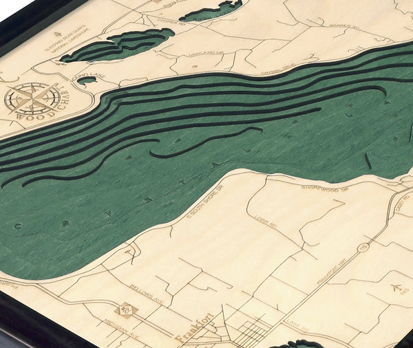 Crystal Lake, Michigan wood chart map made using green and natural colored wood on white background with dark frame up close