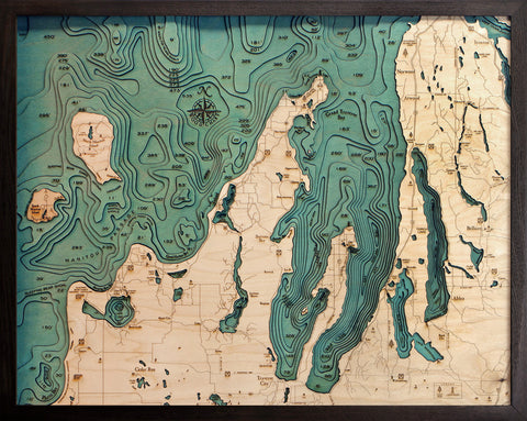 Grand Traverse Bay wood chart map made using green and natural colored wood on black background with dark frame